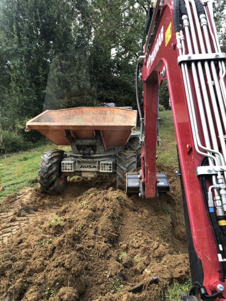 un dumper et une pelle pour évacuer la terre le terrassement d'une piscine naturelle bassin de baignade